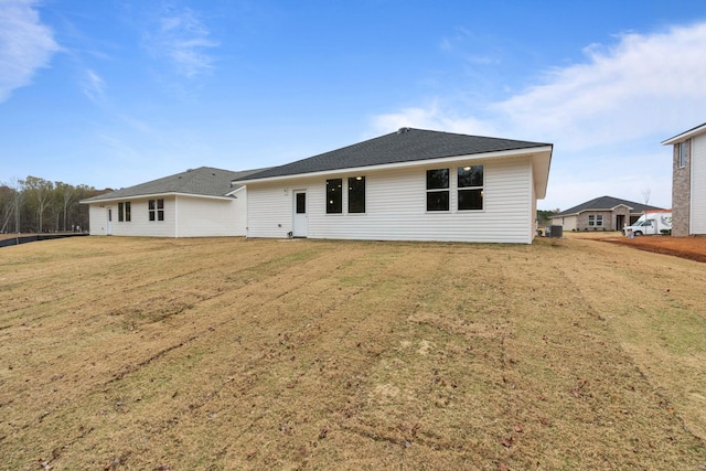 rear view of house featuring a lawn