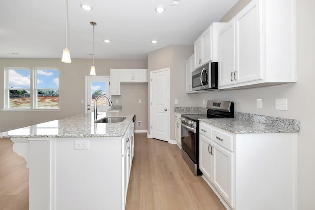 kitchen featuring white cabinetry, sink, stainless steel appliances, an island with sink, and pendant lighting