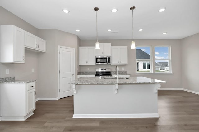 kitchen with white cabinets, appliances with stainless steel finishes, decorative light fixtures, and sink