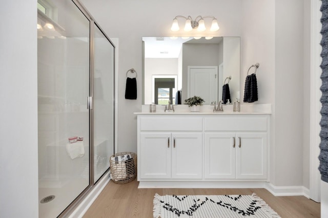 bathroom featuring a shower with door, vanity, and wood-type flooring