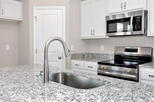 kitchen featuring white cabinets, sink, and appliances with stainless steel finishes