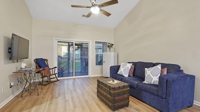 living room featuring ceiling fan, light hardwood / wood-style floors, and vaulted ceiling