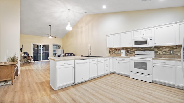 kitchen with white appliances, white cabinets, sink, tasteful backsplash, and kitchen peninsula