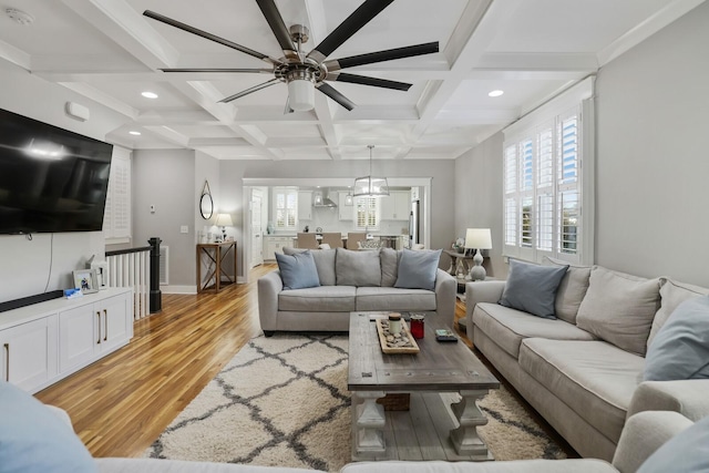 living room featuring beamed ceiling, light wood-type flooring, ceiling fan, and coffered ceiling