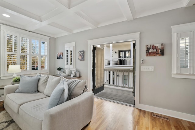 living room featuring beam ceiling, light hardwood / wood-style floors, and coffered ceiling