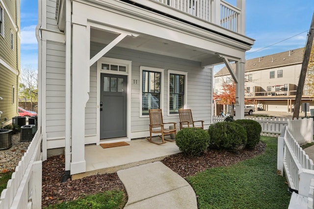 view of exterior entry featuring covered porch and a balcony