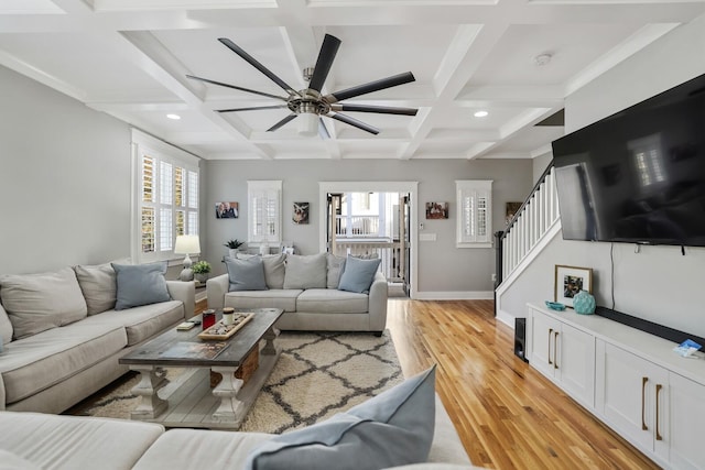 living room featuring beamed ceiling, light hardwood / wood-style floors, a wealth of natural light, and coffered ceiling