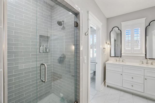 bathroom with vanity, toilet, and a shower with door