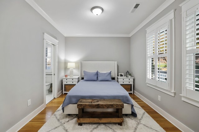 bedroom with multiple windows, wood-type flooring, and ornamental molding