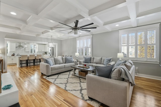 living room featuring beam ceiling, light hardwood / wood-style flooring, and coffered ceiling