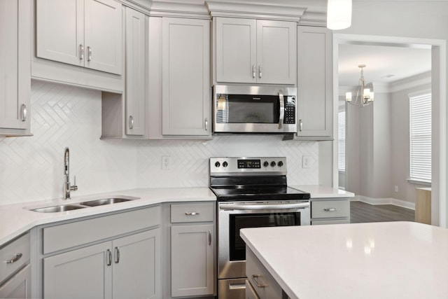 kitchen featuring decorative backsplash, appliances with stainless steel finishes, gray cabinets, and sink