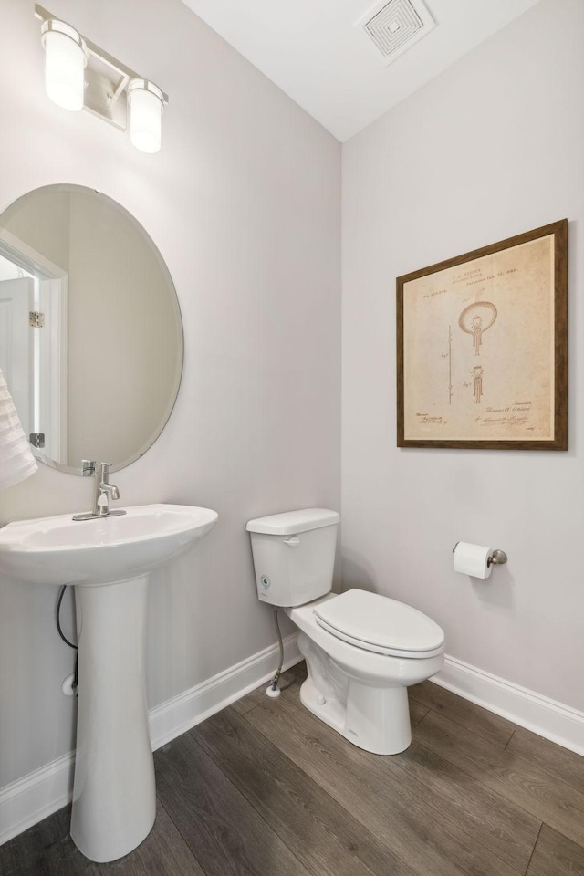 bathroom featuring hardwood / wood-style flooring, toilet, and sink