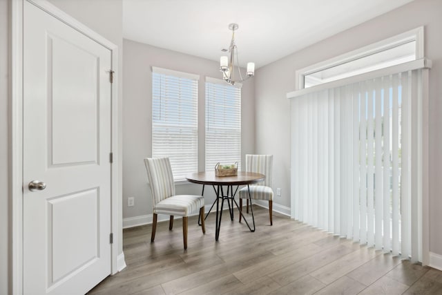 dining space with plenty of natural light, light hardwood / wood-style floors, and a chandelier