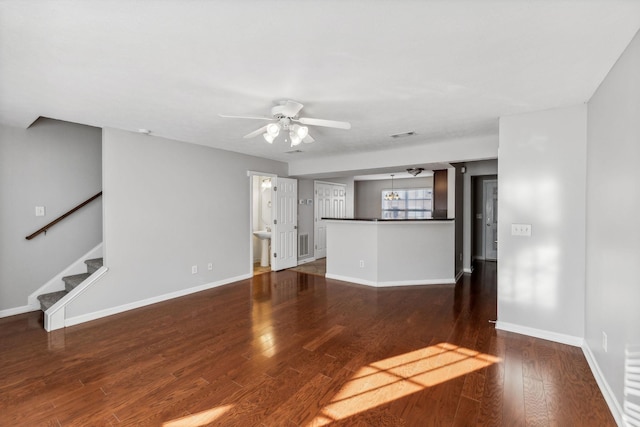 unfurnished living room featuring ceiling fan and dark wood-type flooring