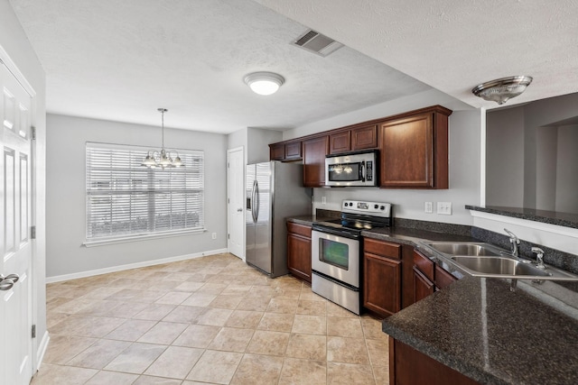 kitchen with sink, hanging light fixtures, a chandelier, a textured ceiling, and appliances with stainless steel finishes