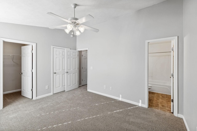 unfurnished bedroom featuring carpet, ensuite bathroom, and ceiling fan