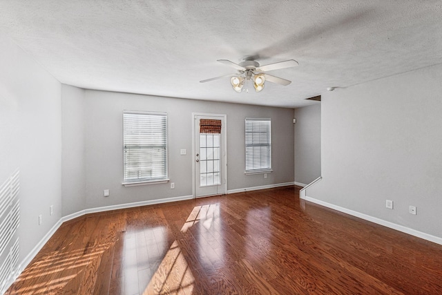 unfurnished room with ceiling fan, dark wood-type flooring, and a textured ceiling