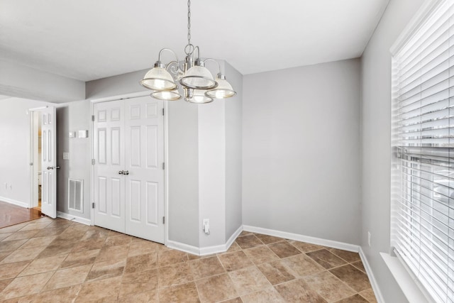 unfurnished dining area with a chandelier