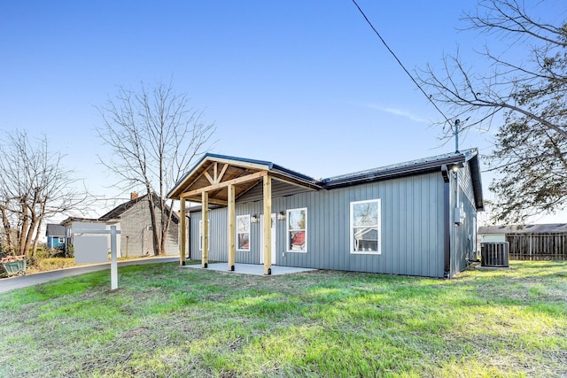 view of front facade featuring a patio area, a front yard, and central air condition unit