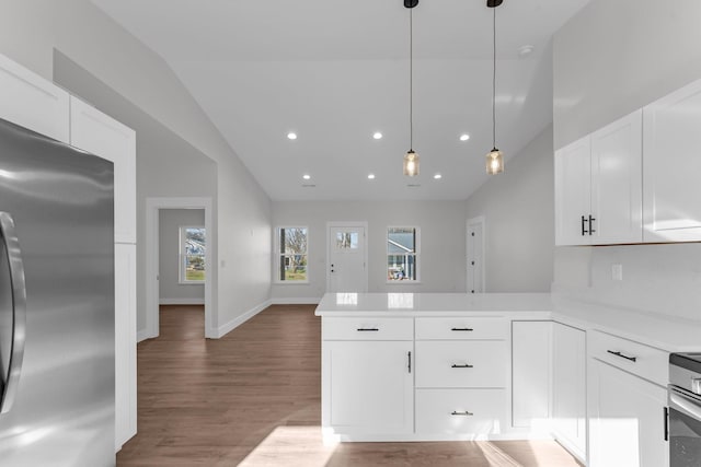 kitchen with white cabinetry, stainless steel refrigerator, and kitchen peninsula