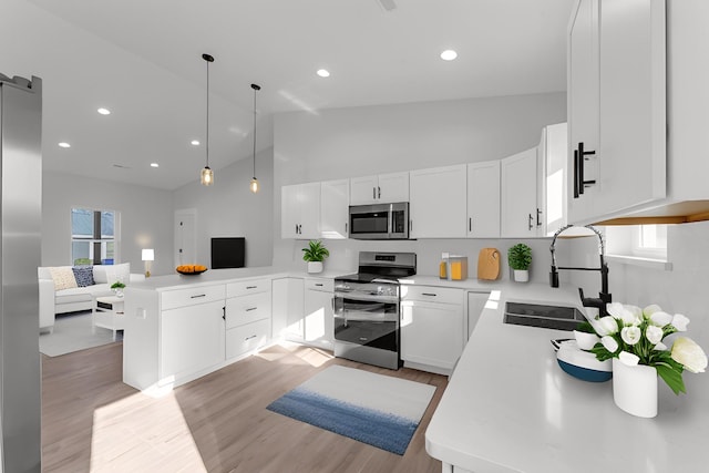 kitchen featuring sink, light hardwood / wood-style flooring, appliances with stainless steel finishes, pendant lighting, and white cabinets