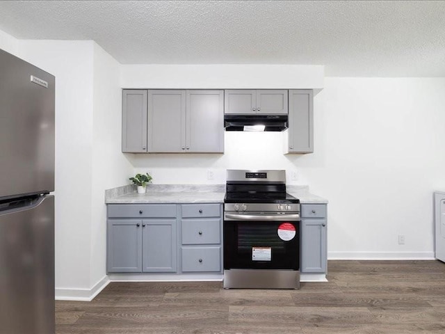 kitchen with appliances with stainless steel finishes, dark hardwood / wood-style flooring, and gray cabinets