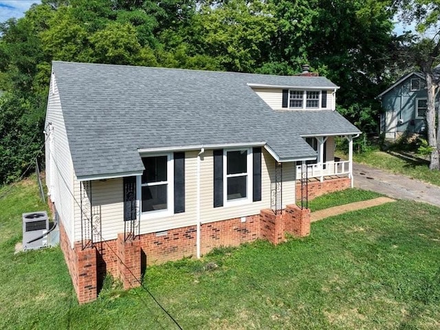 view of front of house featuring a front lawn, covered porch, and central AC unit