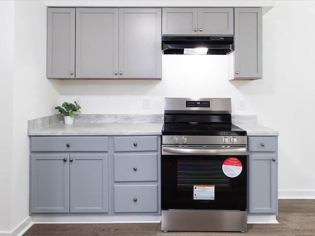 kitchen with gray cabinetry, stainless steel range, dark wood-type flooring, and ventilation hood