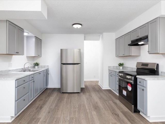 kitchen featuring electric range, sink, light hardwood / wood-style flooring, stainless steel fridge, and gray cabinets