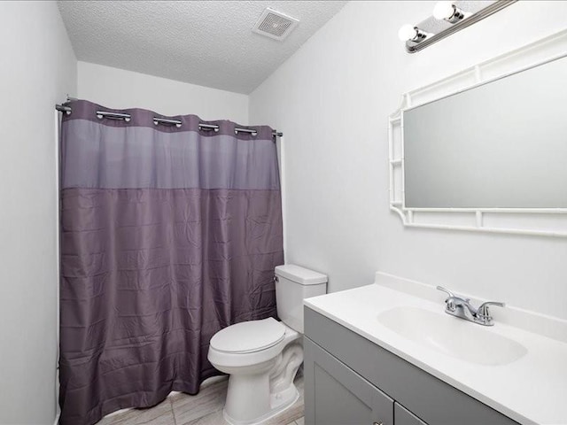 bathroom with vanity, a shower with shower curtain, a textured ceiling, and toilet