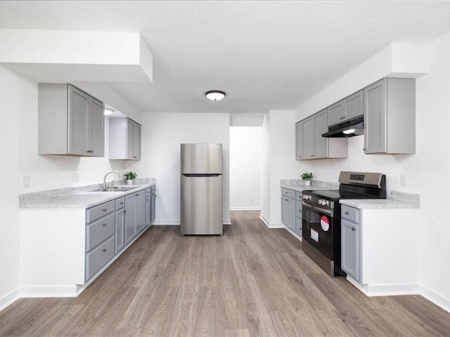 kitchen featuring sink, black electric range oven, stainless steel fridge, light hardwood / wood-style floors, and gray cabinets