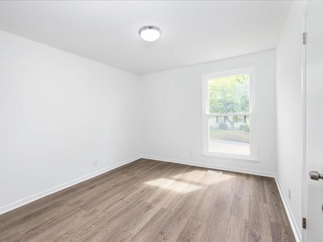 unfurnished room with wood-type flooring