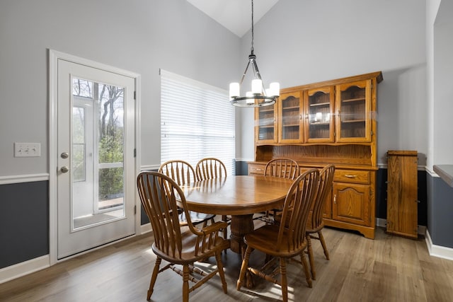 dining room with a chandelier, high vaulted ceiling, and light hardwood / wood-style floors