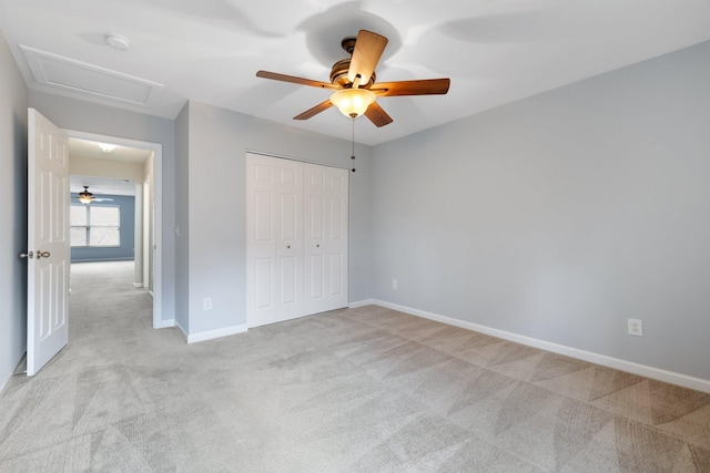 unfurnished bedroom featuring ceiling fan, light carpet, and a closet