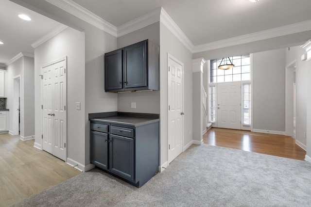 kitchen with light wood-type flooring, ornamental molding, and gray cabinetry