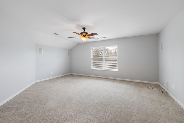 carpeted spare room featuring ceiling fan and lofted ceiling