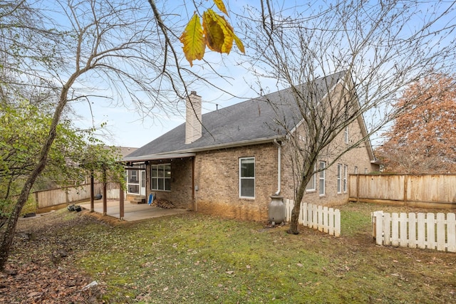 back of property featuring a lawn and a patio area