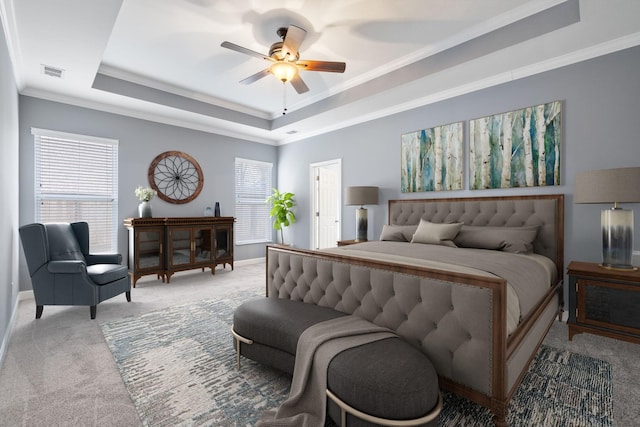 bedroom with ceiling fan, a raised ceiling, ornamental molding, and light carpet