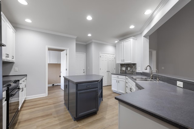 kitchen with black range with electric stovetop, white cabinetry, sink, and light hardwood / wood-style flooring