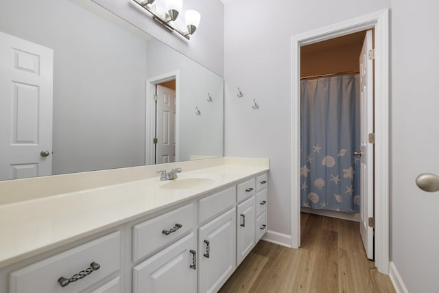 bathroom with curtained shower, hardwood / wood-style floors, and vanity