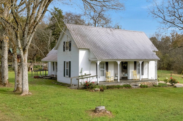 rear view of house with a lawn and a porch