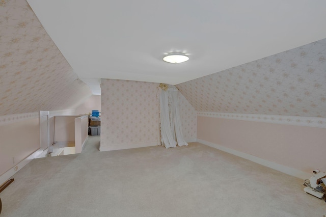 additional living space featuring carpet flooring and lofted ceiling