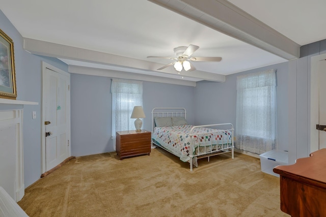 bedroom featuring beamed ceiling, light colored carpet, and ceiling fan