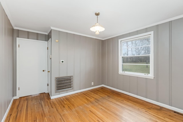 spare room featuring crown molding and hardwood / wood-style floors