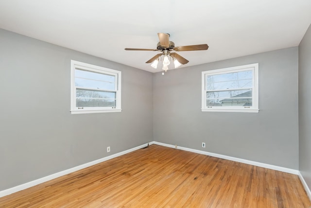 spare room featuring hardwood / wood-style flooring, ceiling fan, and a wealth of natural light