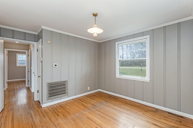 spare room featuring light hardwood / wood-style floors and crown molding