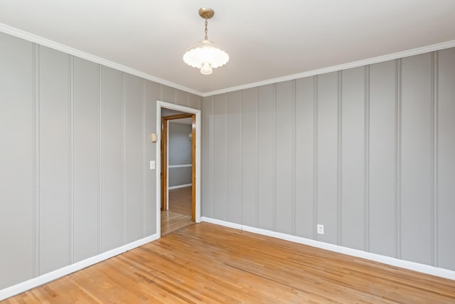 spare room featuring crown molding and hardwood / wood-style flooring