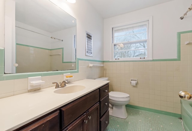 bathroom with tile patterned floors, vanity, toilet, and tile walls