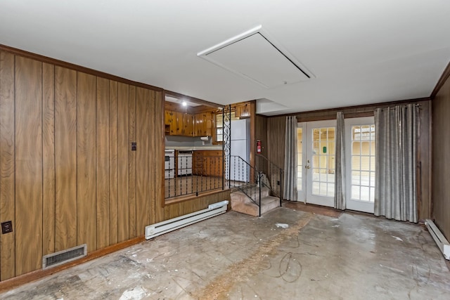 unfurnished room featuring wood walls, concrete flooring, and a baseboard radiator