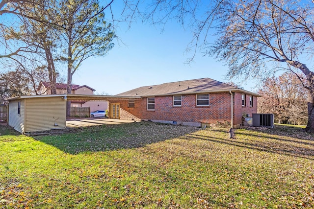 back of house featuring a lawn, a patio area, and central AC